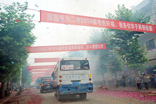 運送考生的車輛依次駛出校門，路邊鞭炮點燃，鑼鼓喧天。