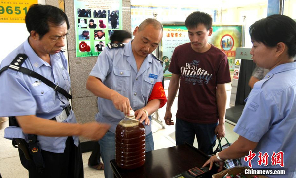 資料圖：7月29日，公安民警和安保人員正在克拉瑪依客運(yùn)站進(jìn)站口嚴(yán)查進(jìn)站旅客行李和違禁物品。 周建玲 攝