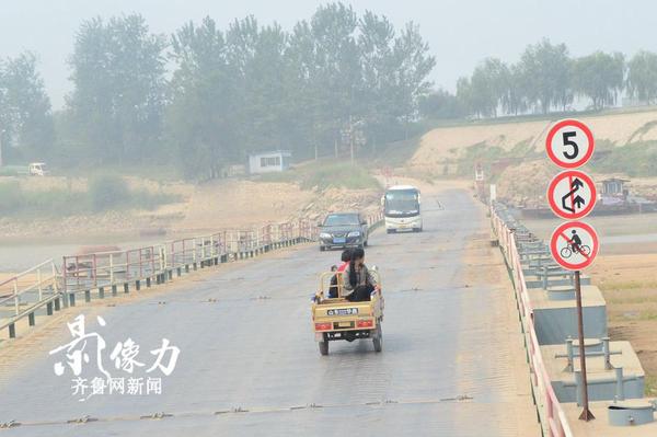 濟南北店子黃河浮橋兩側(cè)也設(shè)有提示牌，禁止自行車上橋，一輛三輪車慢慢駛向?qū)Π?。（圖文 李瑞平）