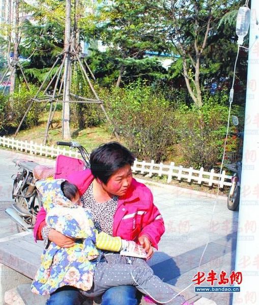 環(huán)衛(wèi)工人劉彩娜陪女兒在路邊打吊瓶