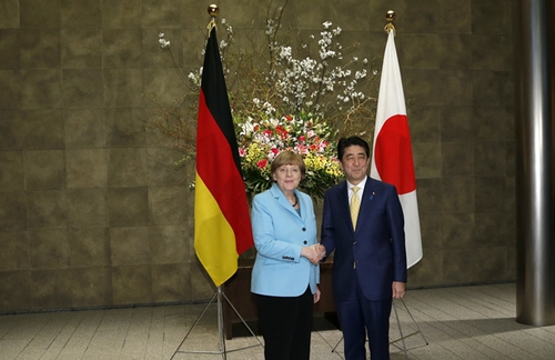 3月9日，在日本東京首相官邸，日本首相安倍晉三（右）歡迎到訪的德國總理默克爾。新華社發(fā)