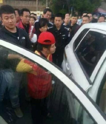 女志愿者被民警帶上警車(chē)，受傷女子則被送醫(yī)救治。