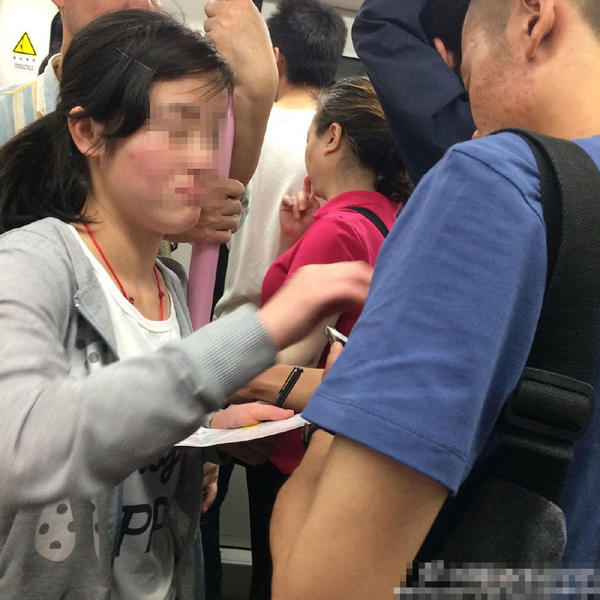 武漢地鐵上的乞討女孩對(duì)男乘客進(jìn)行摸胸討錢。