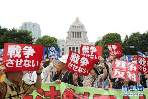 2015年7月14日，日本民眾在國會(huì)外集會(huì)，手舉標(biāo)語牌，高喊口號示威，抗議新安保法