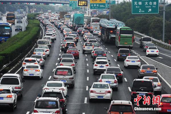 10月1日，江蘇蘇州，國(guó)慶長(zhǎng)假高速公路免費(fèi)通行第一天，沿江高速江蘇省太倉主線收費(fèi)站附近出現(xiàn)數(shù)百米的車流長(zhǎng)龍，從上海方向駛出的大量車輛緩慢通行經(jīng)過沿江高速江蘇太倉段。計(jì)海新 攝 圖片來源 CFP視覺中國(guó)