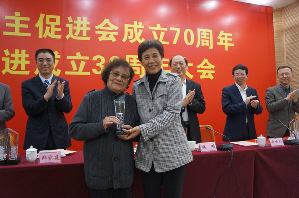 廈門市統(tǒng)戰(zhàn)部部長黃菱給入會60周年97歲高齡的民進會員謝植桂頒發(fā)榮譽獎杯。