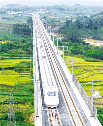 　12月3日，一輛試運(yùn)行的“和諧號”列車從廣西南寧市隆安縣境內(nèi)的一座高架橋經(jīng)過。韋萬忠攝（新華社發(fā)）