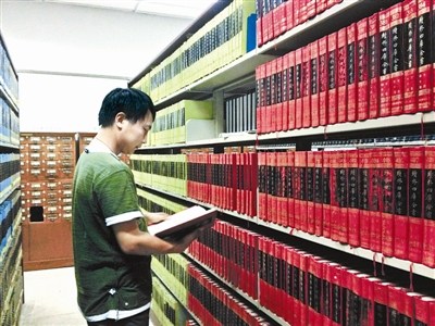 資料圖：一名古籍愛好者正在北大古籍閱覽室翻看“四庫全書”。圖片來源：北京青年報