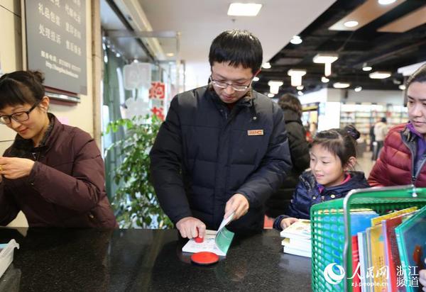 圖書管理員給新書加蓋杭州圖書館公章。