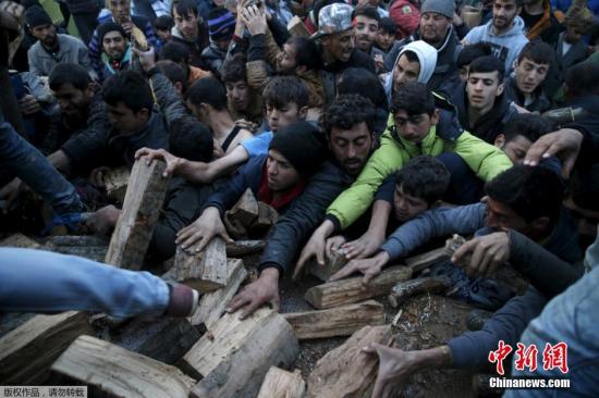 當?shù)貢r間2016年3月6日，希臘Idomeni，滯留希臘與馬其頓邊境的移民蜂擁爭搶木柴。