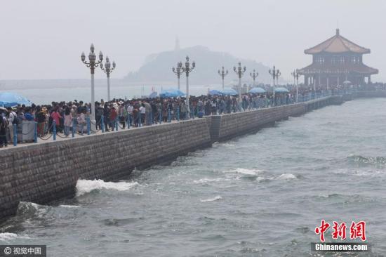 看海還是看人海？4月30日，青島棧橋的小清新氣息全無(wú)，只剩下緩慢挪動(dòng)的各位盡情享受無(wú)盡的海風(fēng)。 圖片來(lái)源：視覺中國(guó)