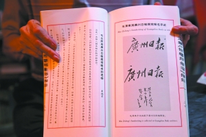 屈干臣展示毛澤東為廣州日?qǐng)?bào)題寫的報(bào)名手跡（原手跡收藏于廣州日?qǐng)?bào)檔案室）