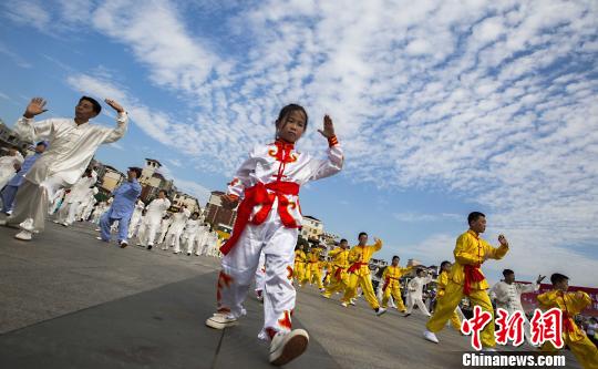 少年太極拳愛好者在江西都昌縣一廣場(chǎng)上表演太極拳?！「到ū蟆z