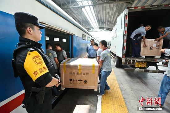 圖為6月29日，在北京站，文物保護(hù)人員將?；韬钗奈锇徇\(yùn)上列車(chē)。 張學(xué)東 攝