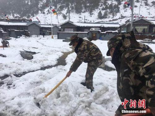 3月11日，西藏公安邊防總隊機動支隊應急二分隊官兵正在鏟除道路積雪。 張鈺 攝