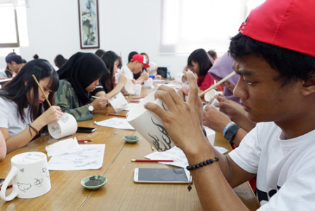 印度尼西亞學生正在繪制青花瓷茶杯圖案。(華僑大學華文學院供圖：楊惠晶 張芬妮)