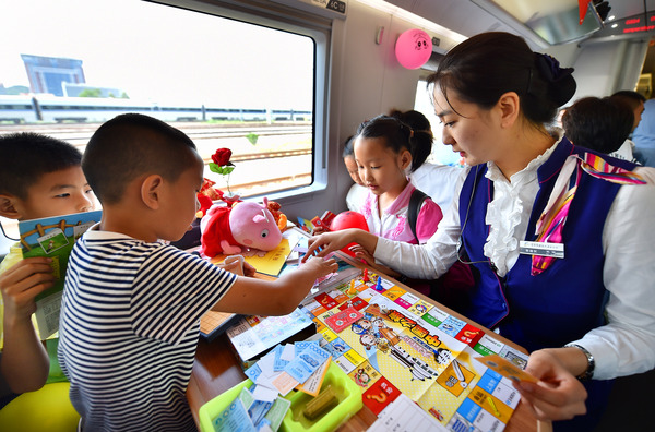 北京鐵路局天津客運(yùn)段值乘的廈門(mén)北至北京南G324次列車(chē)乘務(wù)員與兒童旅客互動(dòng)做游戲。