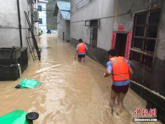 圖為浙江省麗水市遂昌縣民警在積水中準(zhǔn)備營(yíng)救居民。