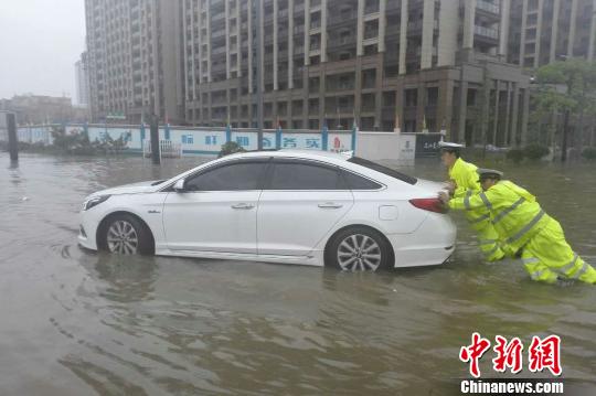 圖為：周宇和隊員在水中推拋錨的車。 金華公安供圖