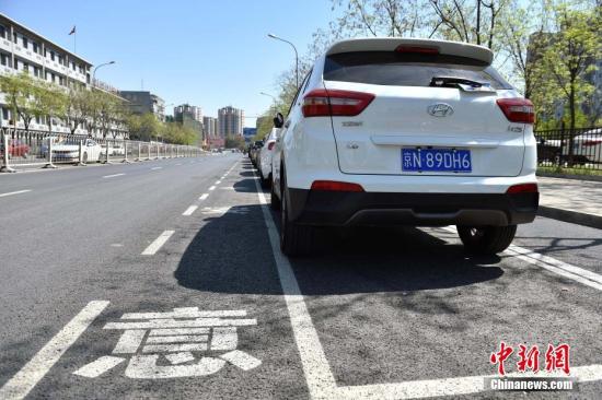 近日，北京市石景山蘋果園南路出現(xiàn)了一種新式路側(cè)停車位，位置從緊貼便道旁邊挪到了機(jī)動車道和非機(jī)動車道中間。據(jù)交管部門介紹，這樣的停車位在全市還屬首創(chuàng)，目的是為了解決停車難的同時保障非機(jī)動車的路權(quán)。新式路側(cè)停車位設(shè)置在路南側(cè)近30余個，位于兩條機(jī)動車道和一條非機(jī)動車道中間，停車位內(nèi)已經(jīng)都停滿了私家車，騎車人使用最外側(cè)的自行車專用道，與行駛的機(jī)動車隔離開來，互不影響。停車位左側(cè)還劃有一米左右寬的虛線邊框，提醒司機(jī)“注意安全”。<a target='_blank' href='http://www.chinanews.com/' >中新網(wǎng)</a>記者 金碩 攝