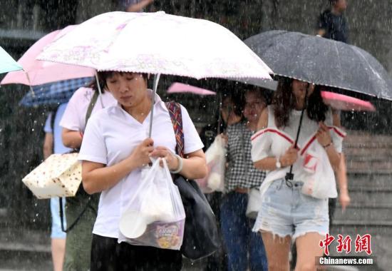 7月31日上午，臺風(fēng)“海棠”給福州帶來暴雨，市民冒著大雨出行。今年第10號臺風(fēng)“海棠”于當天02時50分在福清市沿海登陸，登陸時中心附近最大風(fēng)力8級(18米/秒，熱帶風(fēng)暴級)，中心最低氣壓990百帕。 劉可耕 攝