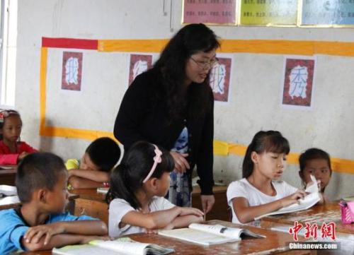 9月22日，在偏遠山區(qū)的廣西柳江縣穿山鎮(zhèn)六廟小學(xué)，幾間瓦房教室、宿舍，操場上3張乒乓球臺就是學(xué)生和老師的一切。48歲的韋鳳玲在給學(xué)生們上課，“下雨時，人在上課雨從頭頂落”，韋鳳玲這樣形容學(xué)校環(huán)境。2014年從老撾完成兩年支教任務(wù)的柳江縣第二中學(xué)教師韋鳳玲，又到該縣土博鎮(zhèn)、穿山鎮(zhèn)村級小學(xué)支教，被稱為支教“專業(yè)戶”。朱柳融 攝