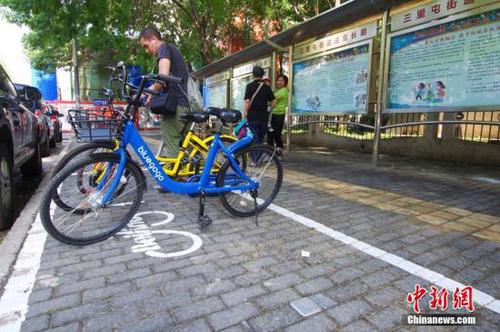 資料圖：一位外國(guó)友人正在北京三里屯地區(qū)的一處共享單車電子圍欄內(nèi)歸還單車。<a target='_blank' href='http://www.chinanews.com/'>中新社</a>記者 賈天勇 攝