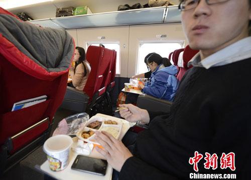 資料圖：圖為動車組乘客在品嘗列車提供的餐食。<a target='_blank' href='http://www.chinanews.com/'>中新社</a>發(fā) 侯宇 攝