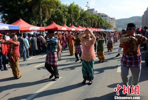 踩街隊伍在美食街上穿行表演，整個活動現(xiàn)場成為歌舞的海洋?！埥鸫āz