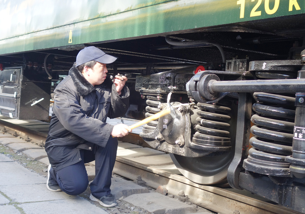 3-周國強正在對火車的運行設備進行檢修