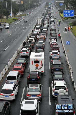 2月23日，車輛在海口市丘海大道排隊等待入港登船。