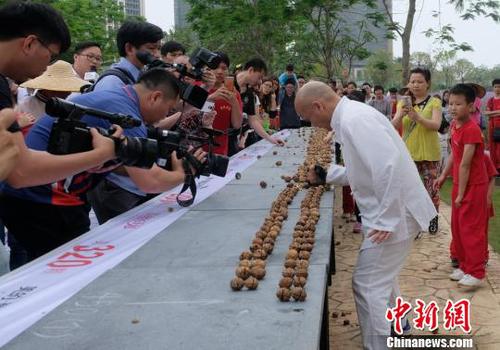 黎偉軍手劈核桃現(xiàn)場(chǎng)吸引不少人圍觀。　程景偉 攝