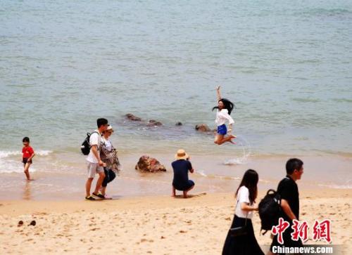 資料圖：端午假期，游客在三亞海邊嬉水。　王曉斌 攝