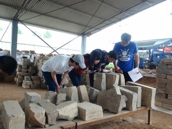 圖7 中國人民大學(xué)研究生在曹魏大墓工地現(xiàn)場考察出土墓磚（李重蓉?cái)z影）