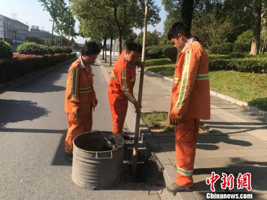 浙江省杭州市西湖區(qū)市政監(jiān)管科工作人員潘旭陽(左二)在清理淤泥。　胡哲斐 攝