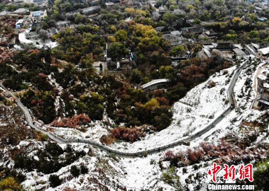 11月4日早晨，航拍視角中的蘭州城區(qū)一角，繽紛秋色中點(diǎn)綴著點(diǎn)點(diǎn)白雪?！钇G敏 攝