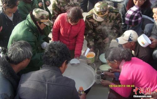 官兵在營地與災(zāi)民共同吃飯。武警玉樹支隊(duì) 趙飛 供圖