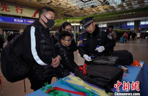 12月28日，北京西站派出所民警為背黑色雙肩包的旅客系上個(gè)性小標(biāo)識(shí)，以防在通過(guò)安檢或乘車(chē)過(guò)程中出現(xiàn)錯(cuò)拿情況。(完) 龐賀雷 攝