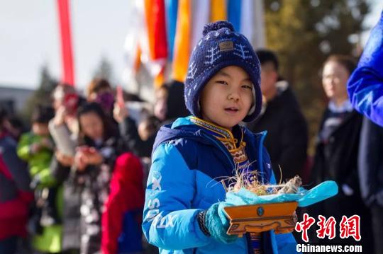 圖為小孩拿著貢品準(zhǔn)備祭火。　胡杰 攝