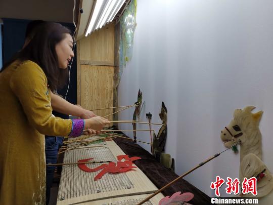 李娟藏在幕布后，繪聲繪色地為觀眾表演《西游記之孫悟空大戰(zhàn)蝎子精》?！≮w曉 攝