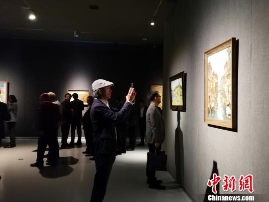 圖為，在“印象山東——俄羅斯油畫家寫生作品展”上，觀眾在喜歡的作品前駐足觀賞、拍照?！O宏瑗 攝