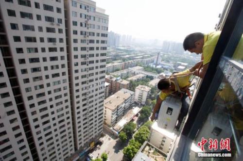 資料圖：在山西太原，空調(diào)安裝工程師頂著酷暑高溫，為市民安裝空調(diào)。<a target='_blank' href='http://www.chinanews.com/'>中新社</a>記者 張?jiān)?攝