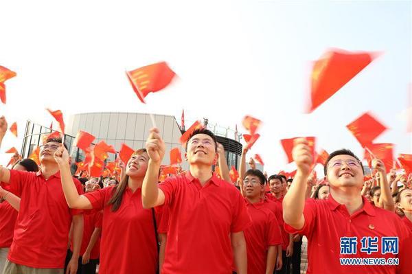 9月26日，在廣東東莞民盈·國貿(mào)中心，粵港澳青年揮舞國旗，合唱《歌唱祖國》。新華社記者 李嘉樂 攝