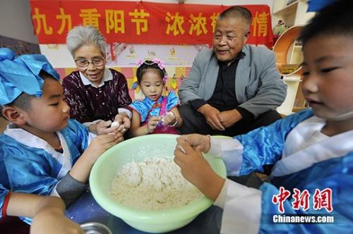 資料圖：小朋友與老人共做重陽(yáng)糕。 孟德龍 攝