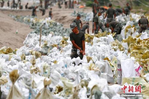 資料圖：7月25日，江西省九江市柴桑區(qū)江洲鎮(zhèn)北堤，中國(guó)人民解放軍第71集團(tuán)軍某部官兵正在為防洪備料。