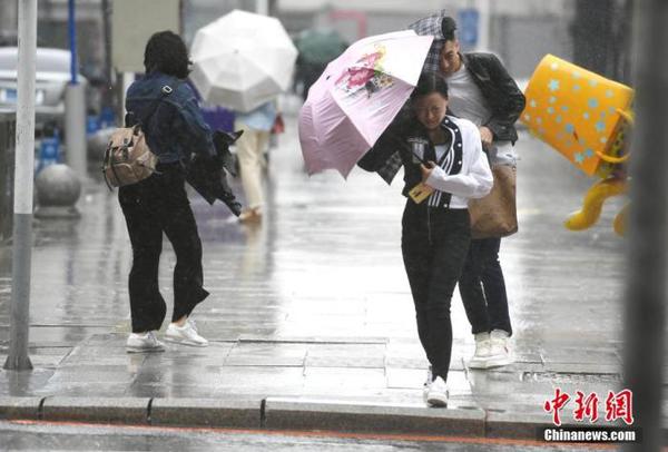 資料圖：市民頂風冒雨出行。 中新社記者 張瑤 攝